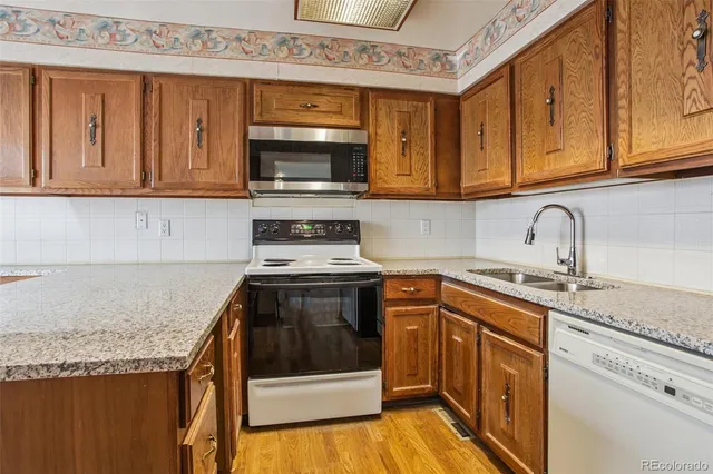 a kitchen with stainless steel appliances granite countertop a sink stove and microwave