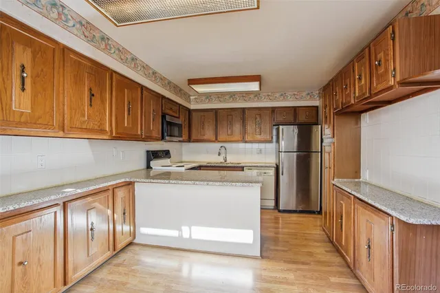 a kitchen with stainless steel appliances granite countertop a refrigerator and a stove top oven