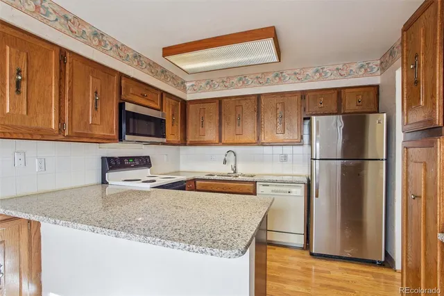 a kitchen with stainless steel appliances granite countertop a refrigerator sink stove microwave and cabinets