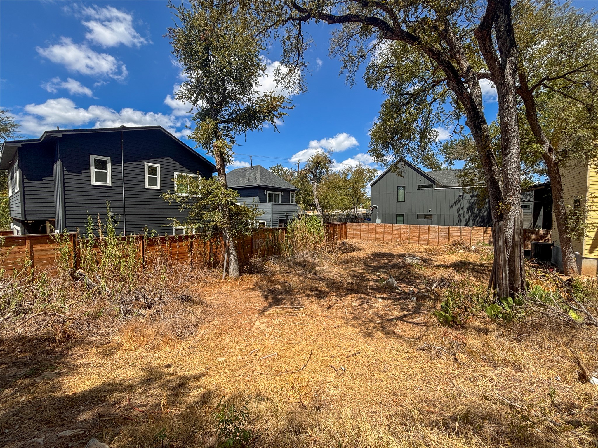 4602 Santa Anna Street Austin, TX 78721 - Photo 11 of 14 Mature trees shade a spacious back yard enclosed by wooden fencing.