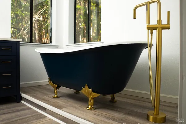 a view of house with a small yard and large trees