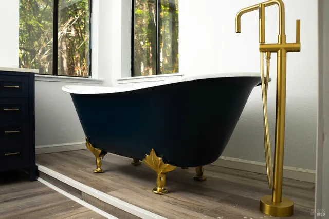 a view of house with a small yard and large trees