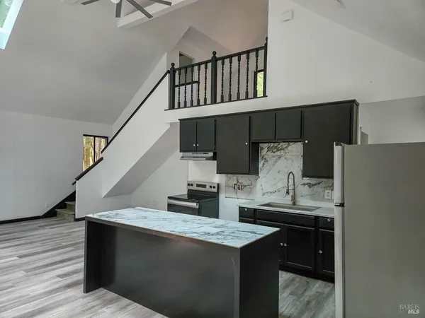 a kitchen with stainless steel appliances granite countertop a stove a sink and a refrigerator