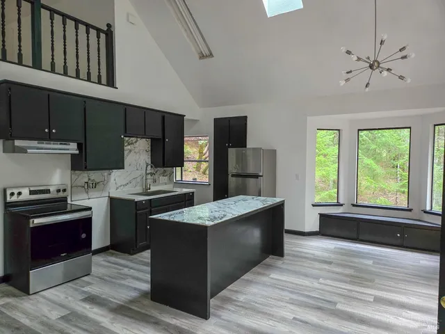a kitchen with stainless steel appliances granite countertop a stove a sink and a refrigerator