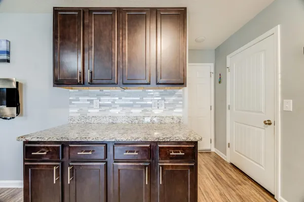 a view of a storage and utility room with wooden floor