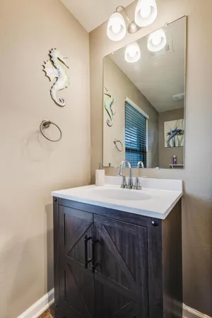 a bathroom with a granite countertop sink a mirror and vanity