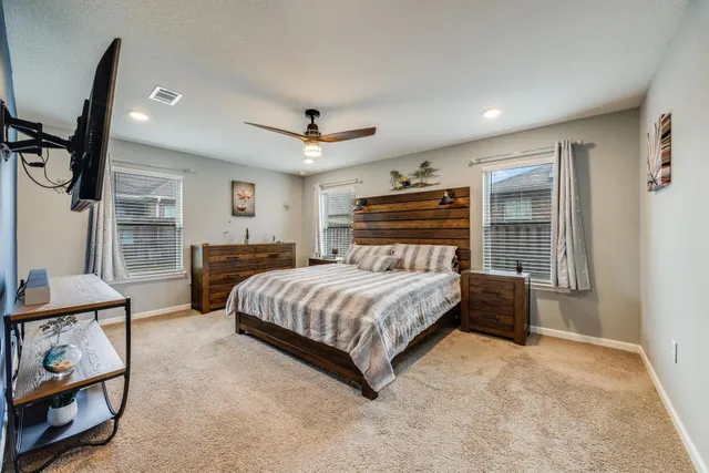 a bedroom with a bed window and dresser