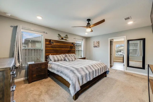 a bedroom with a large bed large window and closet