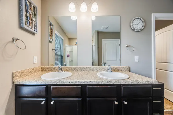 a bathroom with a granite countertop sink a mirror and a table