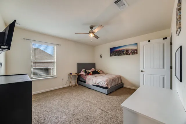 a bedroom with furniture and a flat screen tv
