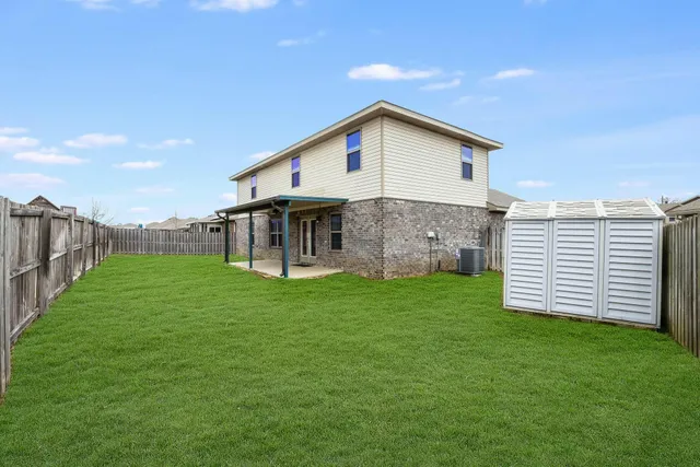 a view of a backyard with plants and large trees