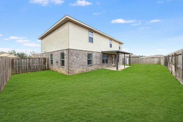 a view of a house with backyard and garden