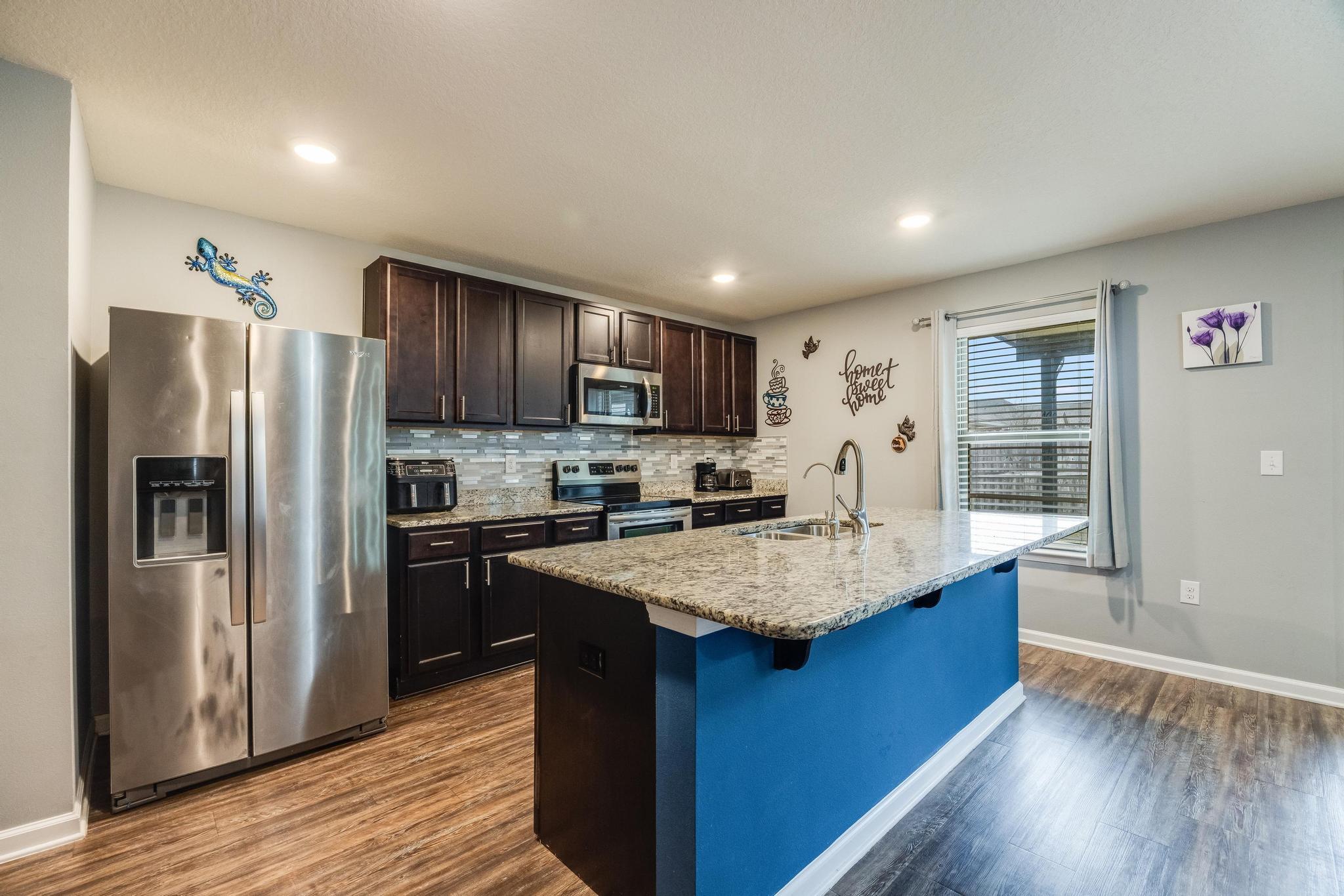 367 Merlin Court Crestview, FL 32539 - Photo 9 of 46 a kitchen with kitchen island granite countertop wooden cabinets a refrigerator and a stove