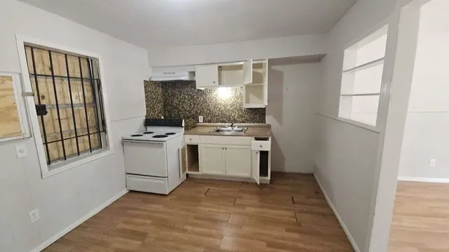 a kitchen with a stove a sink and a window