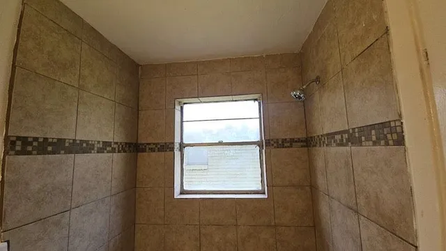 a bathroom with a window and a shower