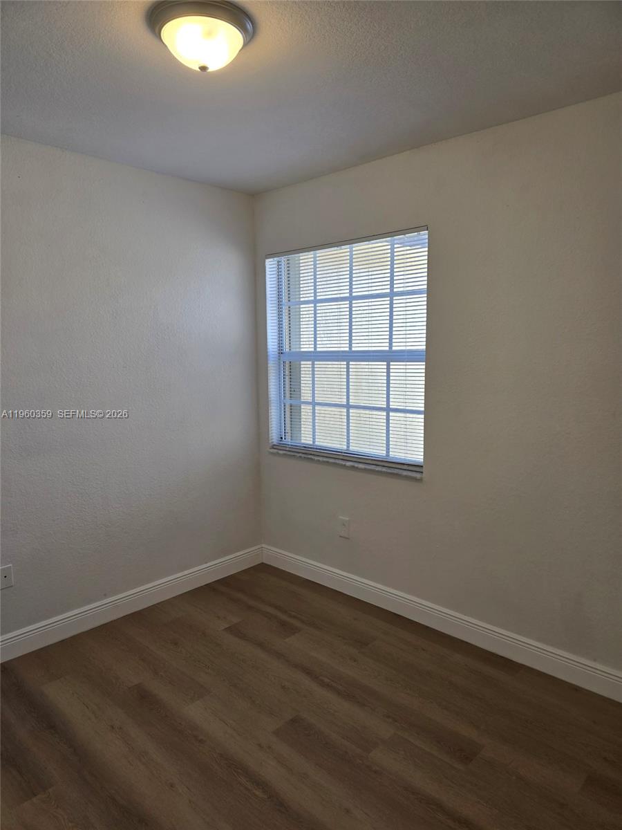 1575 Northeast 33rd Avenue, Unit 1049 Homestead, FL 33033 - Photo 22 of 22 an empty room with wooden floor and windows