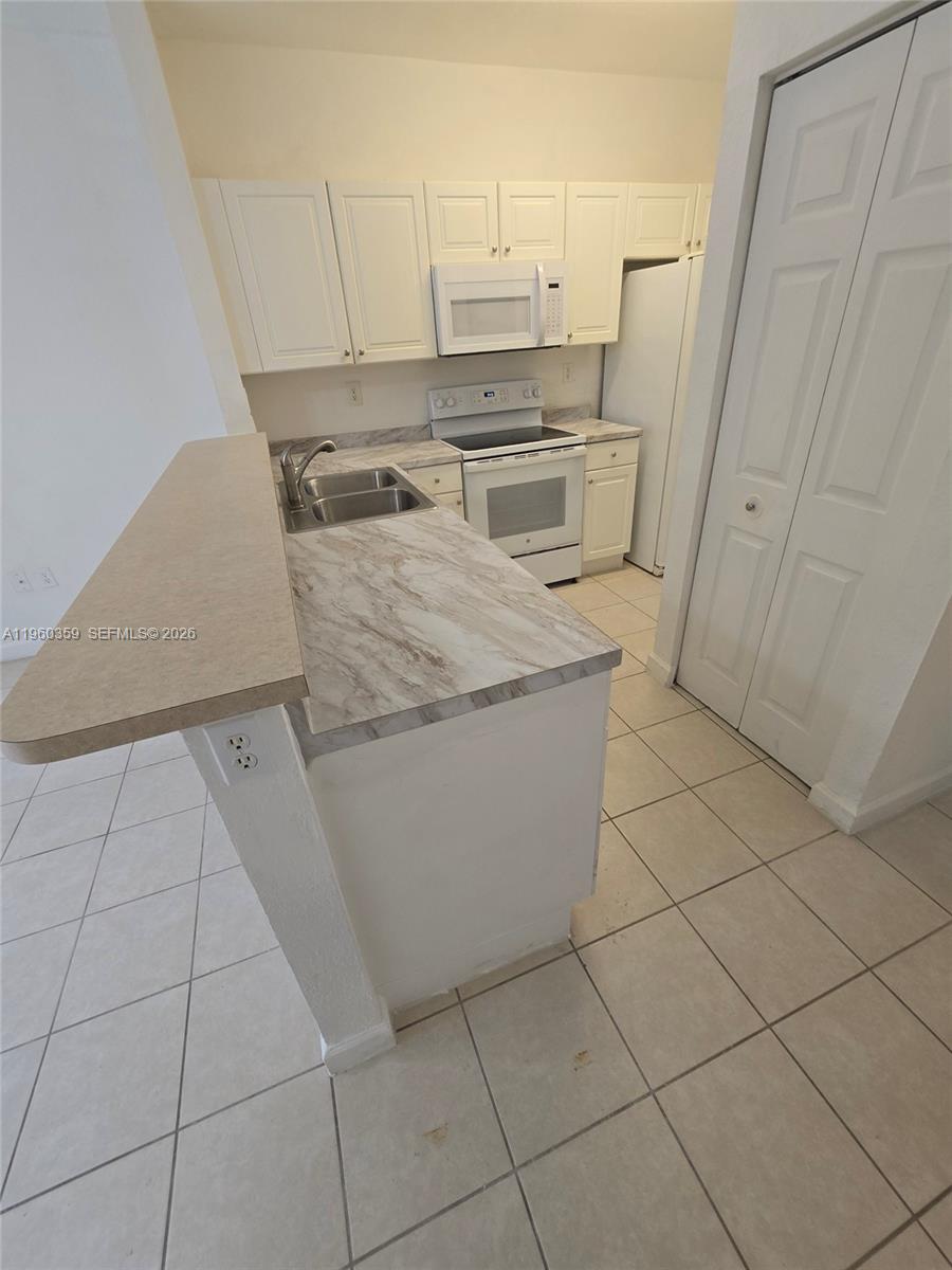 1575 Northeast 33rd Avenue, Unit 1049 Homestead, FL 33033 - Photo 6 of 22 a kitchen with a sink and cabinets