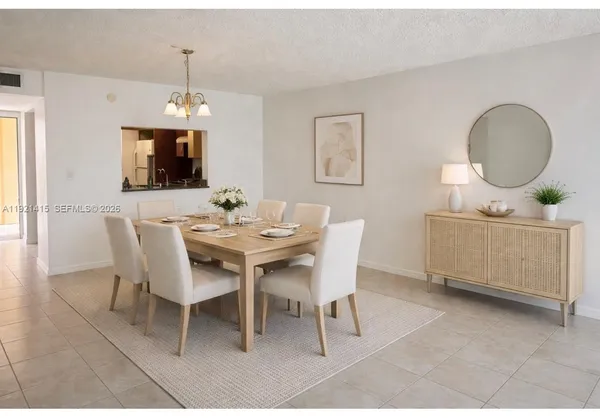a dining room with furniture a rug a potted plant and a chandelier