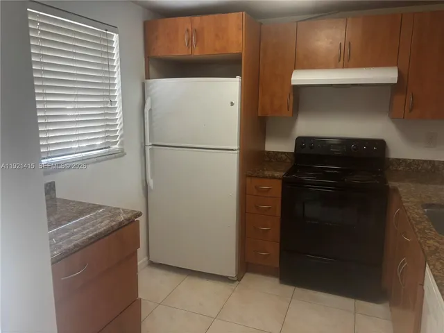 a kitchen with a refrigerator and a stove