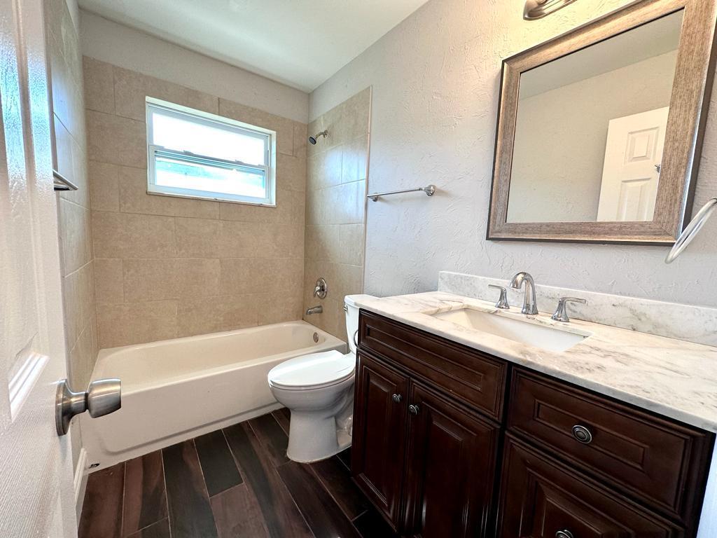 848 Center Street, Unit 3 Jupiter, FL 33458 - Photo 2 of 9 a bathroom with a granite countertop toilet sink and mirror