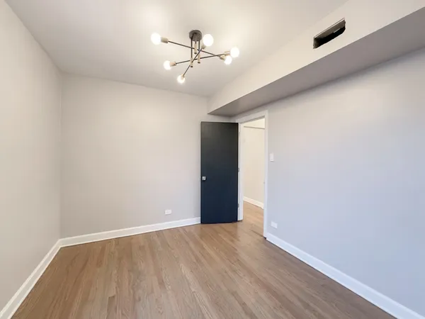 an empty room with wooden floor and a fireplace