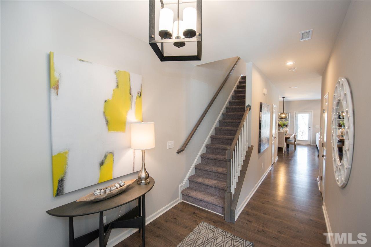3607 Water Mist Lane, Unit 25 Raleigh, NC 27604 - Photo 3 of 24 a hallway with painting on the wall and a potted plant