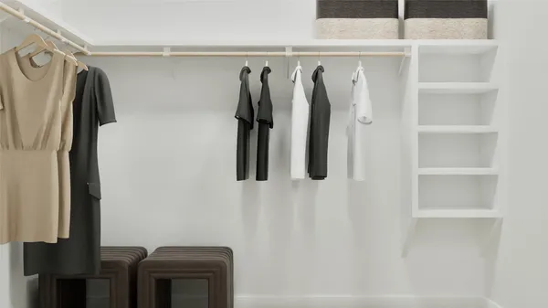 a view of walk in closet with clothes and shoes