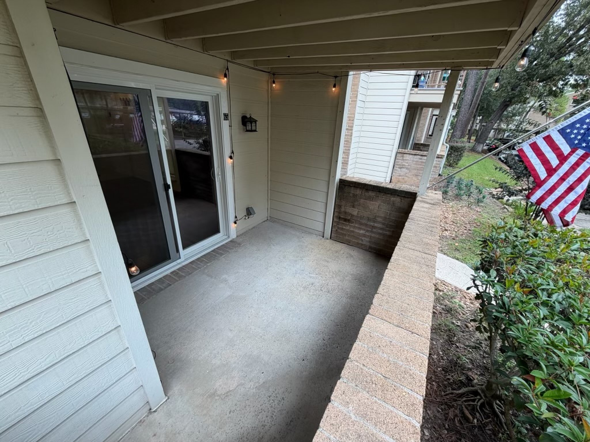 3500 Tangle Brush Drive, Unit 65 Spring, TX 77381 - Photo 17 of 20 Covered patio offers a comfortable outdoor extension of the living space, with plenty of room for seating and direct access through sliding glass doors—perfect for relaxing or enjoying the surrounding greenery.