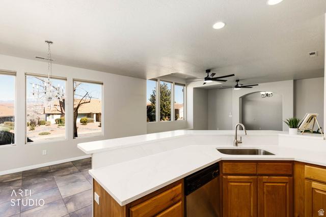 2158 Balboa Way St. George, UT 84770 - Photo 8 of 40 Kitchen with brown cabinetry, a chandelier, stainless steel dishwasher, a ceiling fan, and light stone countertops