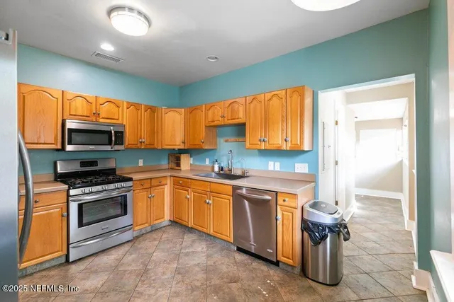 a kitchen with stainless steel appliances kitchen island granite countertop a stove top oven a sink and dishwasher
