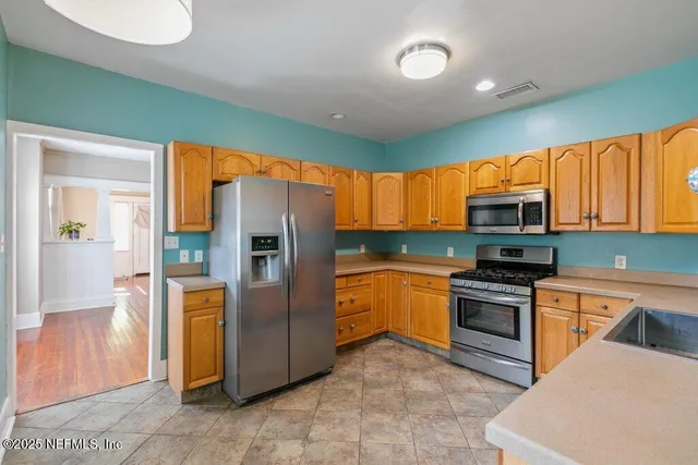 a kitchen with stainless steel appliances granite countertop a refrigerator and a stove top oven