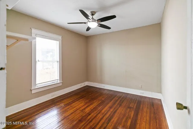 wooden floor in an empty room with a window