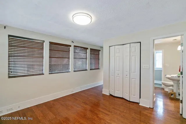 an empty room with wooden floor and a window
