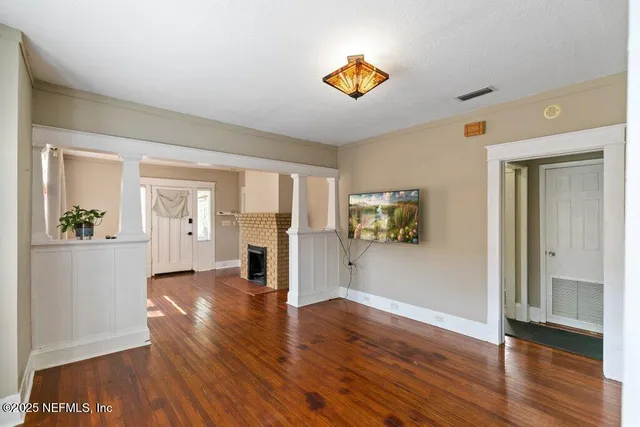 a view of a hallway with wooden floor and dining room