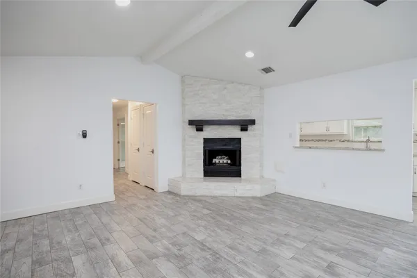 a view of empty room with wooden floor and fireplace
