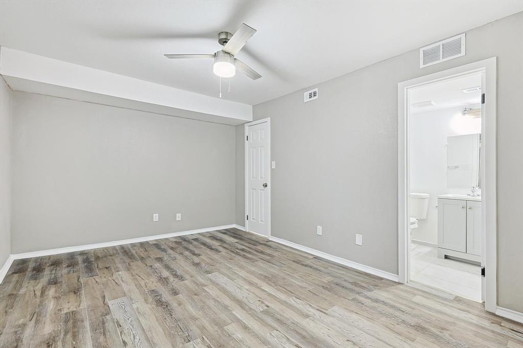 9805 Walnut Street, Unit 201 Dallas, TX 75243 - Photo 19 of 26 Unfurnished bedroom featuring ceiling fan, light hardwood / wood-style floors, and ensuite bath