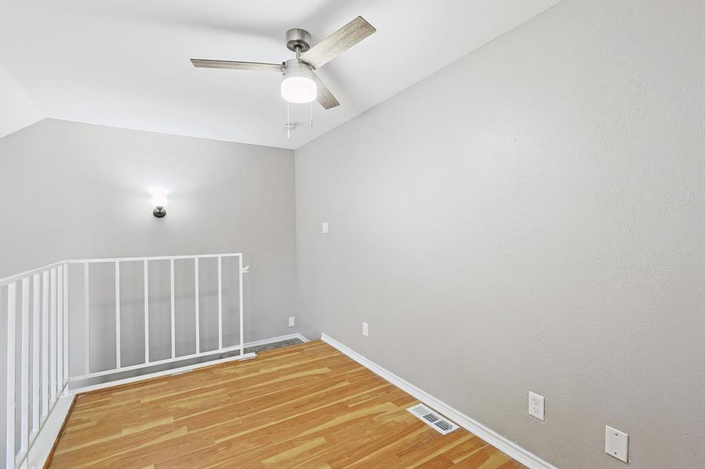 9805 Walnut Street, Unit 201 Dallas, TX 75243 - Photo 21 of 26 Empty room featuring light hardwood / wood-style floors, lofted ceiling, and ceiling fan