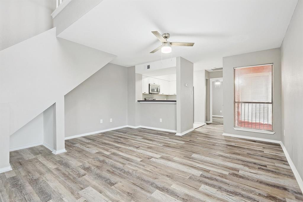 9805 Walnut Street, Unit 201 Dallas, TX 75243 - Photo 3 of 26 Unfurnished living room with ceiling fan and light hardwood / wood-style floors