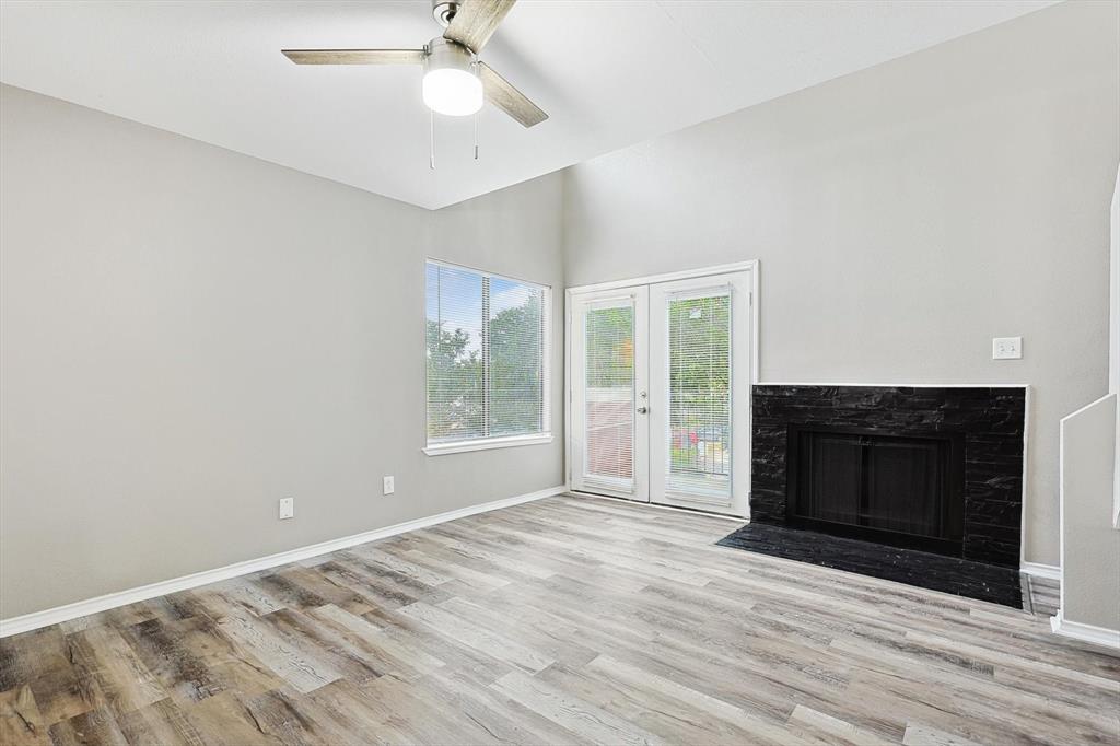 9805 Walnut Street, Unit 201 Dallas, TX 75243 - Photo 5 of 26 Unfurnished living room with a high ceiling, french doors, ceiling fan, and light hardwood / wood-style flooring