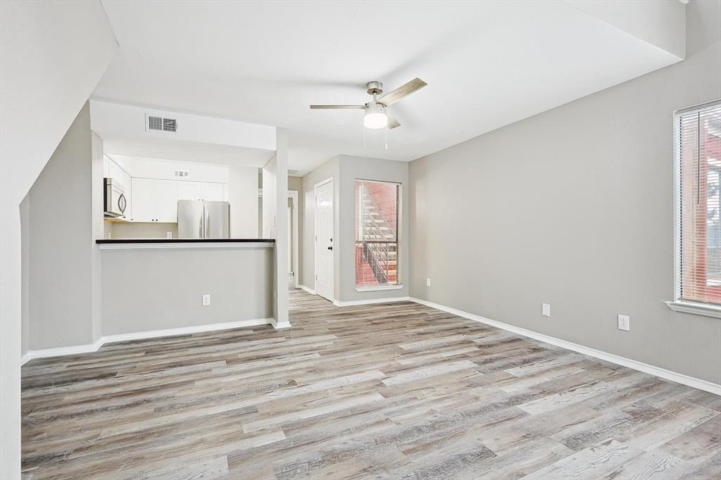 9805 Walnut Street, Unit 201 Dallas, TX 75243 - Photo 6 of 26 Unfurnished living room with plenty of natural light, ceiling fan, and light wood-type flooring