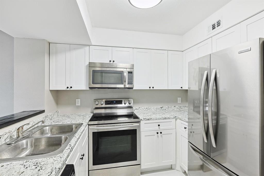 9805 Walnut Street, Unit 201 Dallas, TX 75243 - Photo 8 of 26 Kitchen with white cabinetry, sink, and stainless steel appliances