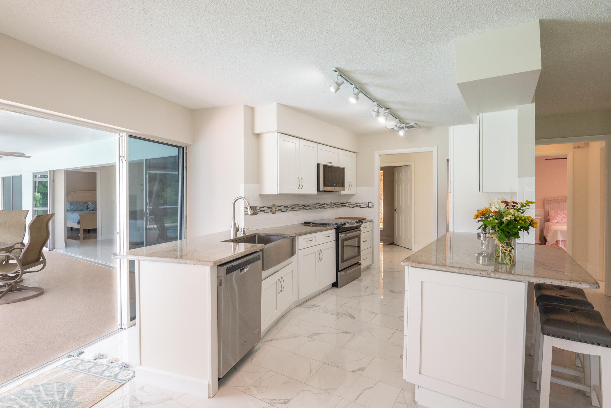 2811 Southeast Fairway West Stuart, FL 34997 - Photo 15 of 40 a kitchen with granite countertop a sink stainless steel appliances and cabinets