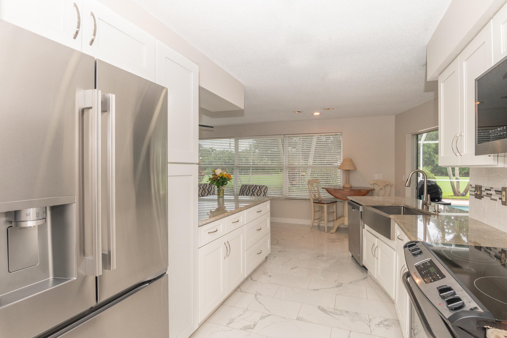 2811 Southeast Fairway West Stuart, FL 34997 - Photo 16 of 40 a kitchen with white cabinets and white appliances