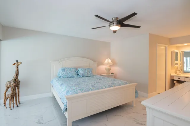a bedroom with a bed and a ceiling fan