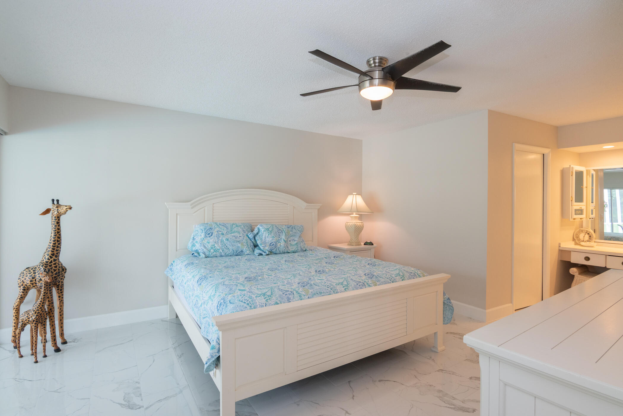 2811 Southeast Fairway West Stuart, FL 34997 - Photo 23 of 40 a bedroom with a bed and a ceiling fan