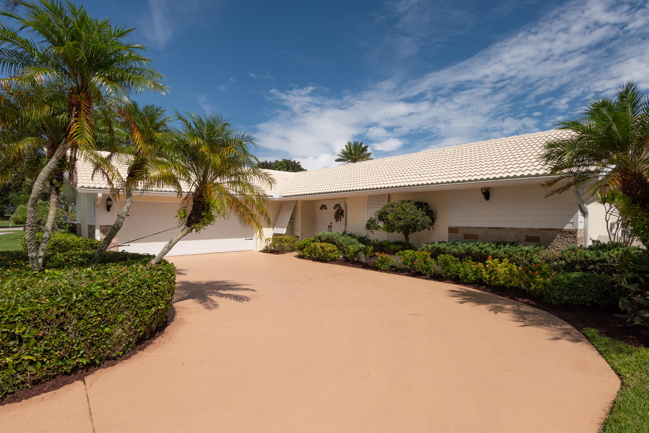 2811 Southeast Fairway West Stuart, FL 34997 - Photo 4 of 40 a front view of a house with a yard and a garage