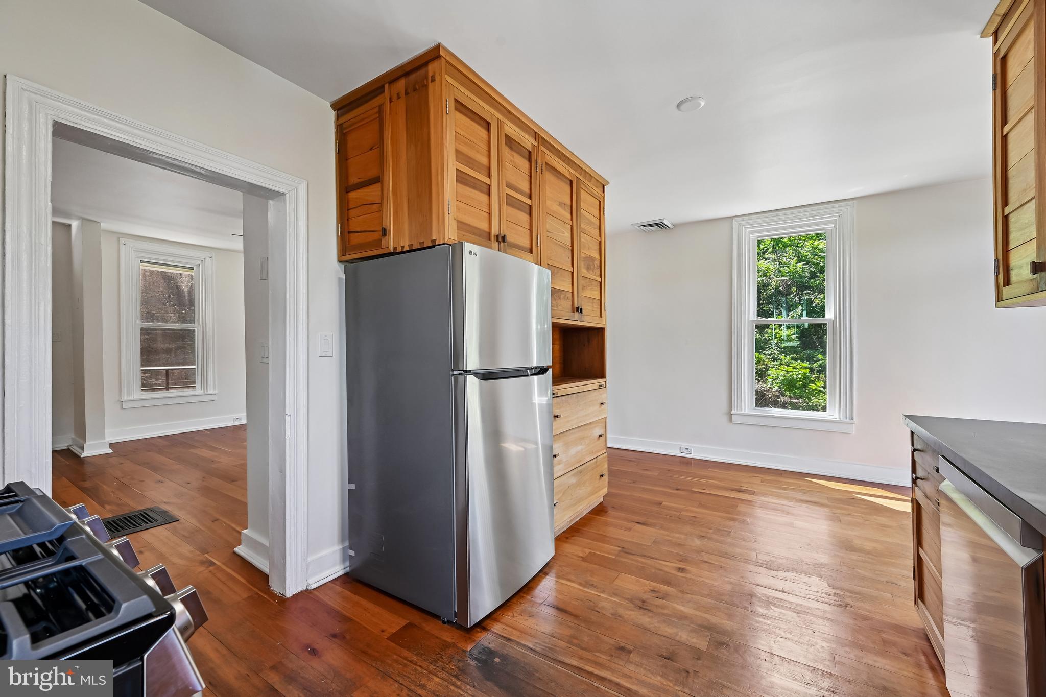 5702 Falls Road Baltimore, MD 21209 - Photo 16 of 49 a kitchen with a refrigerator a stove and a wooden floor
