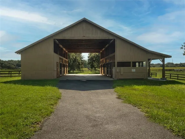 a large kitchen with kitchen island granite countertop a large window cabinets and stainless steel appliances