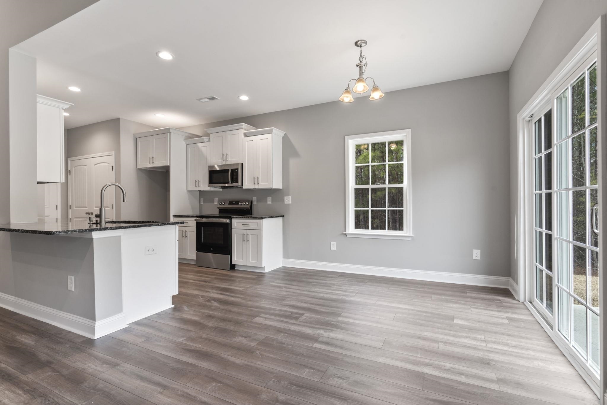 565 Timber Creek Drive Loris, SC 29569 - Photo 19 of 37 Kitchen with appliances with stainless steel finishes, white cabinets, a chandelier, decorative light fixtures, and dark wood-style floors