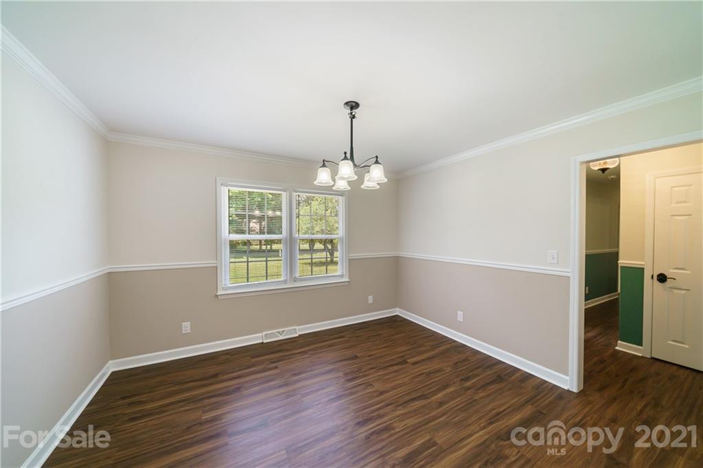 3340 Dan Hood Road Matthews, NC 28105 - Photo 22 of 48 an empty room with wooden floor chandelier and windows